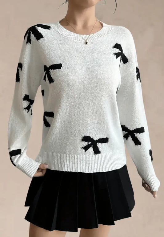 Biały sweter damski z czarnymi kokardkami i okrągłym dekoltem
